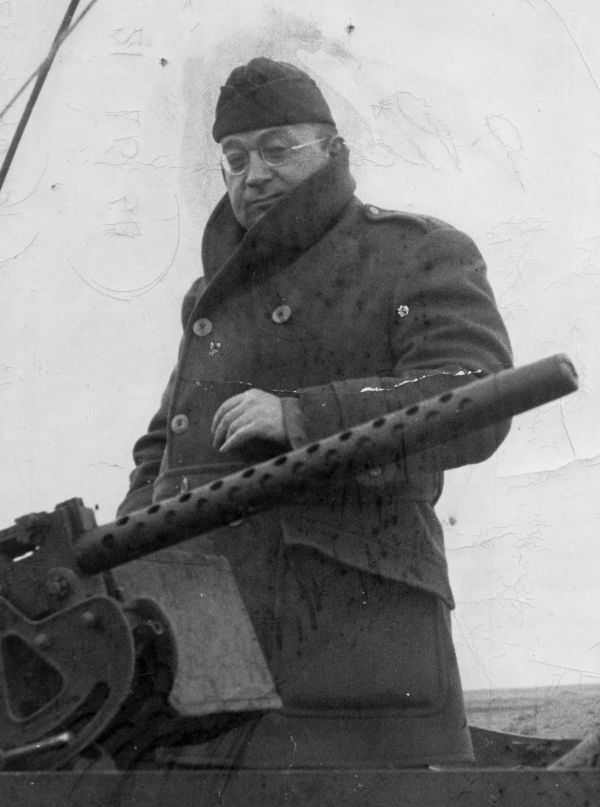 New Yorker writer A.J. Liebling stands beside a machine gun during World War II. Cornell University Library.